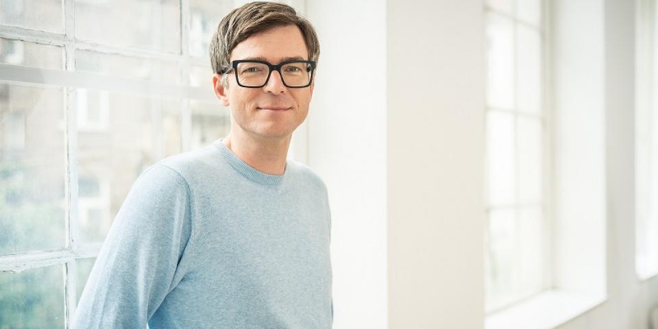 Ein Portrait des Moderators Ralph Caspers vor einem Fenster