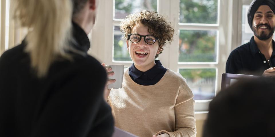 Junge Erwachsene unterhalten sich und lachen.