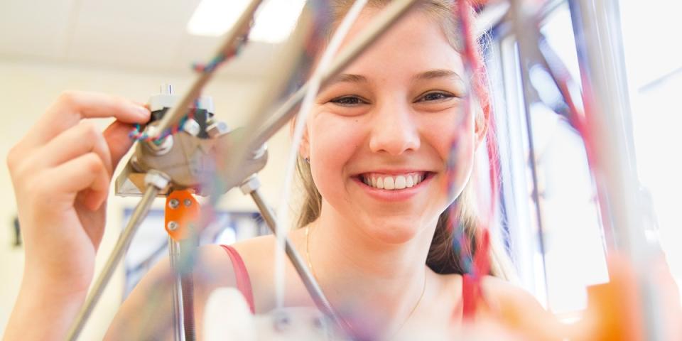 Eine Schülerin experimentiert mit technischen Gerätschaften.