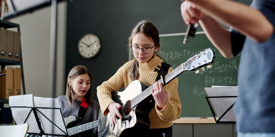 Schülerinnen und Schüler machen zusammen Musik.