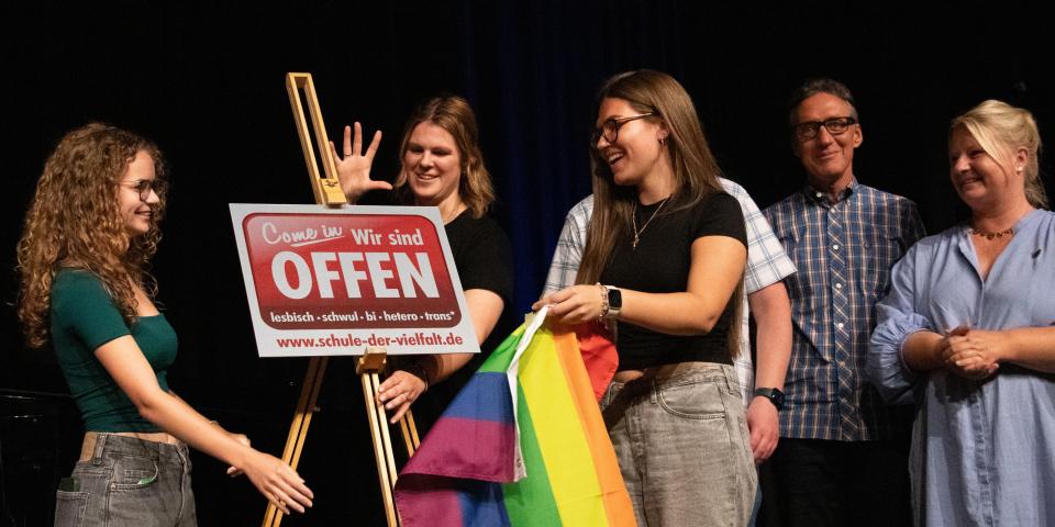 Schülerinnen und Schüler des OHG Monheim enthüllen die Schule der Vielfalt-Plakette.