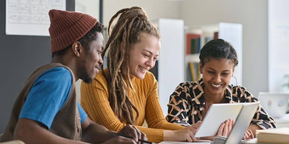 Eine junge Lehrerin arbeitet mit einer Schülerin und einem Schüler aus einer "Fit für mehr"-Klasse zusammen.