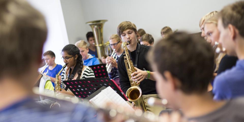 Schüler üben im Musikunterricht ein Musikstück ein. Blasorchester.