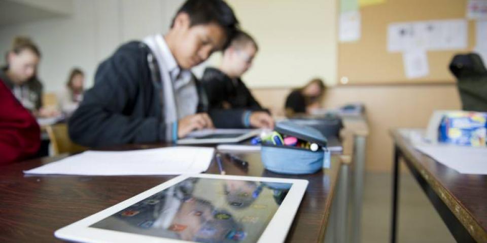 Unterricht in einer Schulklasse. Die Kinder arbeiten mit mobilen Endgeräten 