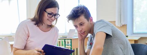 Eine Schulsozialarbeiterin berät einen Schüler.