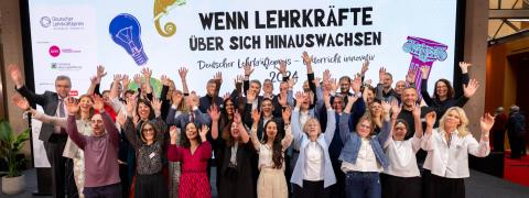 Das Gruppenbild zeigt die Preisträgerinnen und Preisträges des Deutschen Lehrkräftepreises. Sie halten die Hände hoch. 