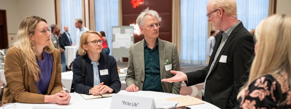 Teilnehmerinnen und Teilnehmer des Stiftungstages stehen zum Gespräch zusammen.
