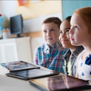 Drei Kinder lernen mit Laptop und Tablet