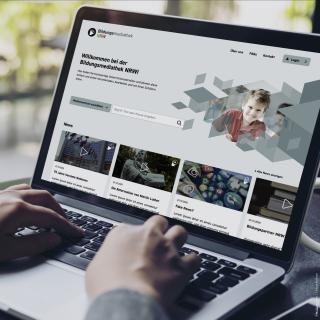 Ein aufgeklappter Laptop zeigt die Startseite der Bildungsmediathek NRW