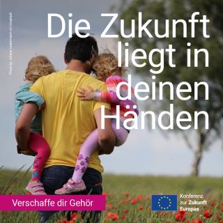 Ein Mann läuft mit zwei Kindern auf dem Arm über eine Wiese mit Mohnblumen.