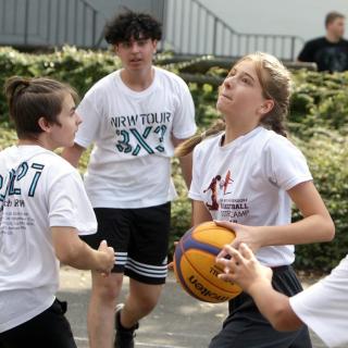 Ein gemischtes Team aus Mädchen und Jugend spielt Basketball bei der NRW3x3Tour.