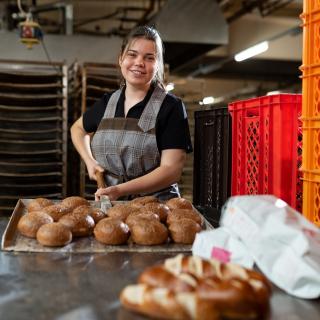 Eine Schüler arbeitet in einer Bäckerei mit.