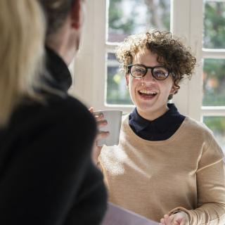 Junge Erwachsene unterhalten sich und lachen.