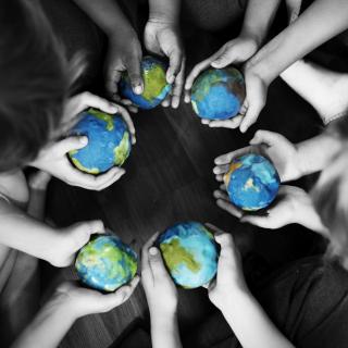 Eine Gruppe Kinder hält kleine Weltkugeln in den Händen.
