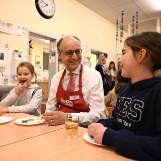 Grundschulkinder frühstücken mit Staatssekretär Dr. Mauer in einem Klassenraum