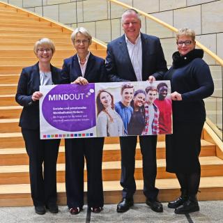 Vor einem Treppenaufgang im Düsseldorfer Landtag stehen Ricarda Steinmayr, Professorin an der Technischen Universität Dortmund, Ministerin Dorothee Feller, Westlotto-Geschäftsführer Andreas Kötter und Alice Bienk, Schulleiterin des Elsa-Brandström-Gymnasiums in Oberhausen