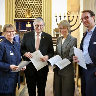 Sylvia Löhrmann, Antisemitismus-Beauftragte des Landes NRW, Abraham Lehrer, Vizepräsident des Zentralrats der Juden in Deutschland, Schulministerin Dorothee Feller und Christoph Pienkoß, Geschäftsführer des Verband Bildungsmedien e.V. stehen zusammen und halten die gemeinsame Empfehlung in den Händen.