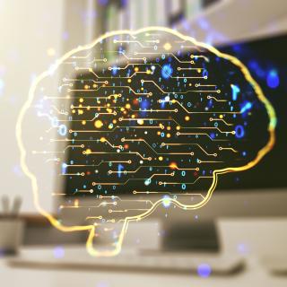 In einem schematisch dargestellten Gehirn sieht man Neuronen aufleuchten.