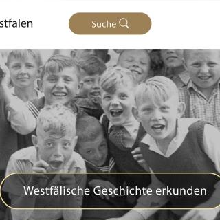 Auf einem erkennbar alten Schwarzweiß-Foto grinsen in die Kamera und schneiden Grimassen.