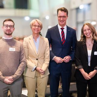 Ministerpräsident Hendrik Wüst und Ministerin Dorothee Feller mit Referendarinnen und Referendaren bei der Vereidigungsfeier in Gelsenkirchen