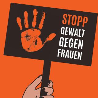 Eine Hand hält ein Plakat mit dem Aufdruck "Stopp Gewalt gegen Frauen"