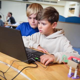 Zwei Schüler sitzen am Laptop.