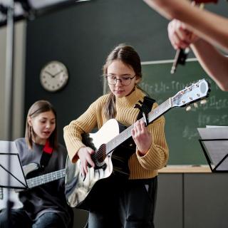 Schülerinnen und Schüler machen zusammen Musik.