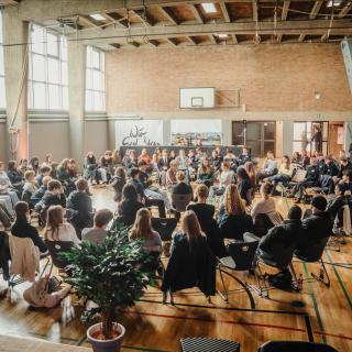 Fishbowl-Diskussion in einer Sportaula mit Holzboden