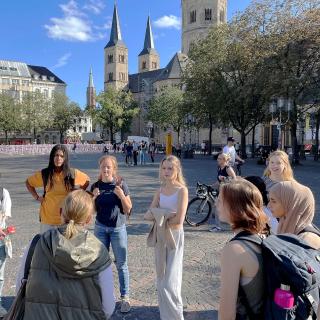 Eine Gruppe Schülerinnen und Schüler steht in Bonn auf dem Münsterplatz.