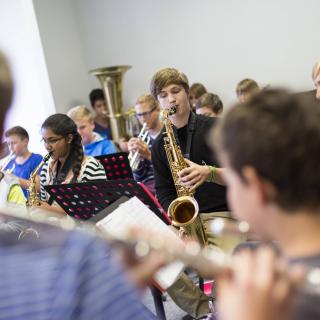 Schüler üben im Musikunterricht ein Musikstück ein. Blasorchester.