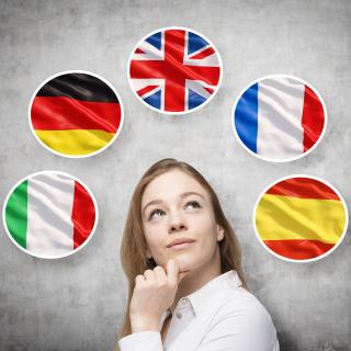 Eine junge Frau vor grauem Hintergrund, über ihr sind in Kreisen die Flaggen Italiens, Deutschlands, Großbritanniens, Frankreihs und Spaniens abgebildet.