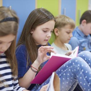 Grundschüler lernen zusammen in einem Schulflur.