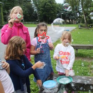 Kinder spielen mit Seifenblasen im Rahmen des Offenen Ganztags der Schmachtenbergschule in Essen.