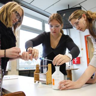 Schülerinnen führen ein naturwissenschaftliches Experiment durch.